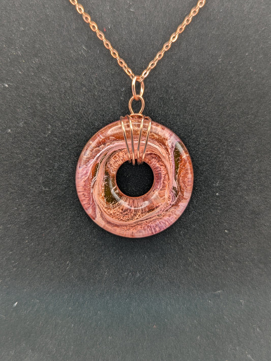 Wire Wrapped Donut Resin Pendant Necklace - Petri Effect with shades of orange, pink, & red swirls. Resin Necklace on a rose gold colored stainless steel plated metal chain.