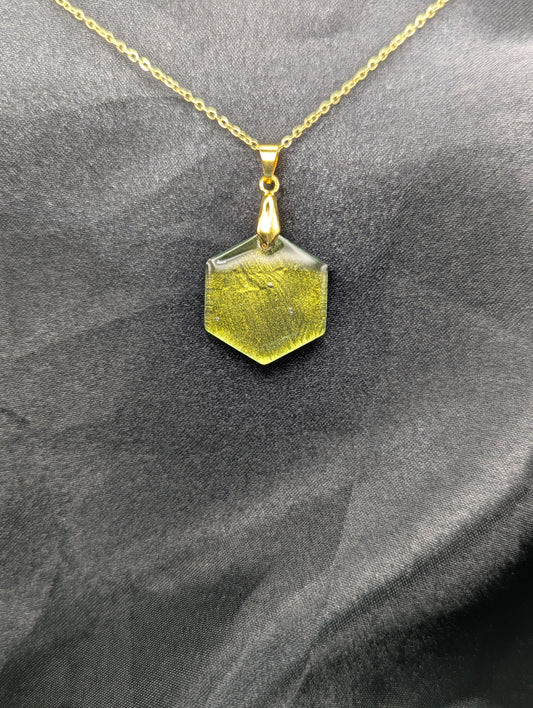 Yellow Hexagon Pendant Necklace with a color shifting background. Resin pendant on a gold pinch bail & gold plated metal chain.
