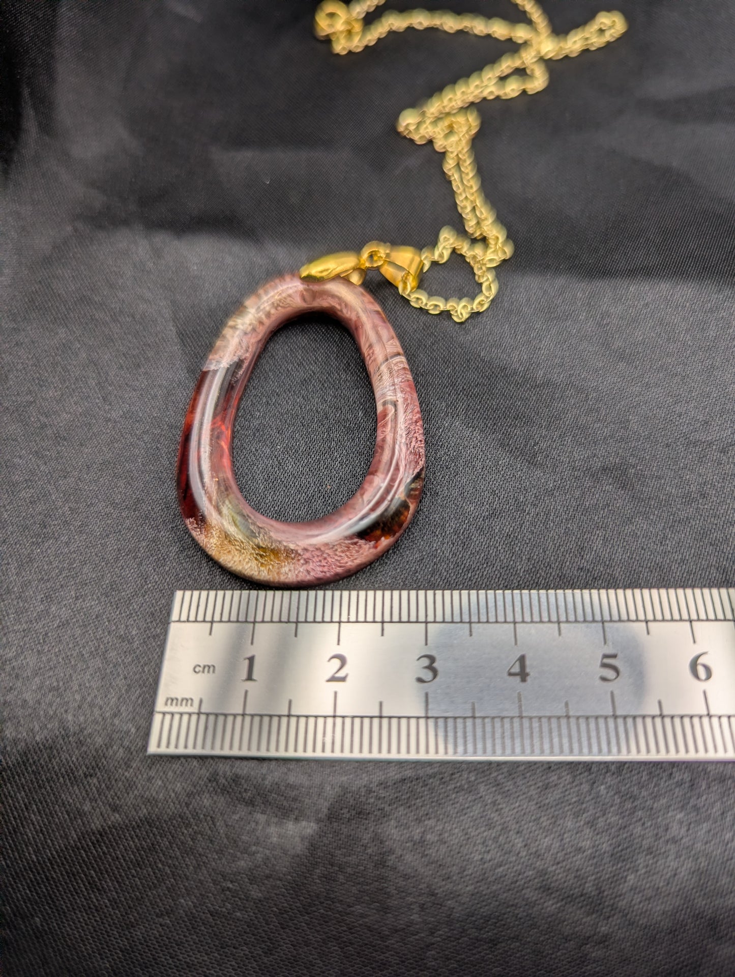 Size example pic of pendant size in centimeters, showing pendant is about 2.5 cm wide.