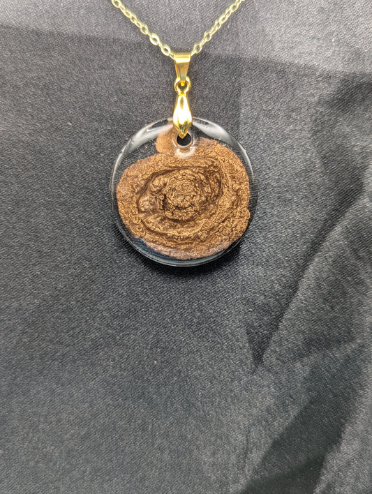 Gold Swirl Resin Circle pendant on a gold pinch bail and gold plated metal chain.