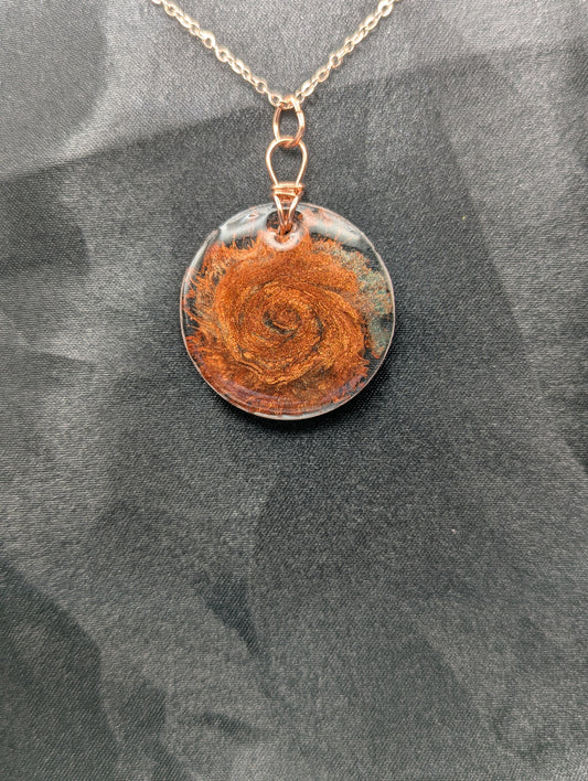 Copper swirl resin circle pendant, wrapped in a pure copper wire on a rose gold colored stainless steel plated metal chain.