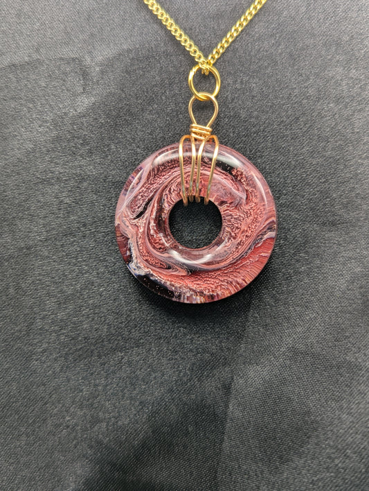 Wire Wrapped Donut Resin Pendant Necklace - Petri Effect with shades of red & black swirls. Resin Necklace on a gold plated metal chain.