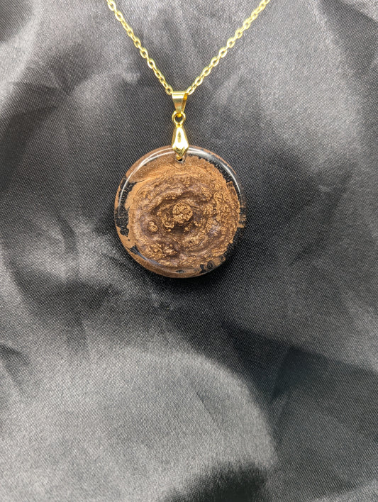 Rich Gold Swirl Resin Circle Pendant on a gold pinch bail and gold plated metal chain.