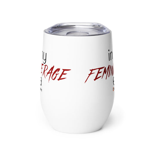 An insulated stemless wine glass with a lid for drinking wine in a tumbler. Cup is white in color with the words "in my feminine rage era". The words "feminine rage" are in red & a different font than the other words (other words are in black)