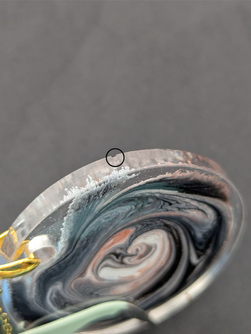 Brown Swirl Circle Pendant with shades of brown, red, & black on a gold pinch bail & golden stainless steel chain. Resin Circle Jewelry Pendant with Petri Effect.