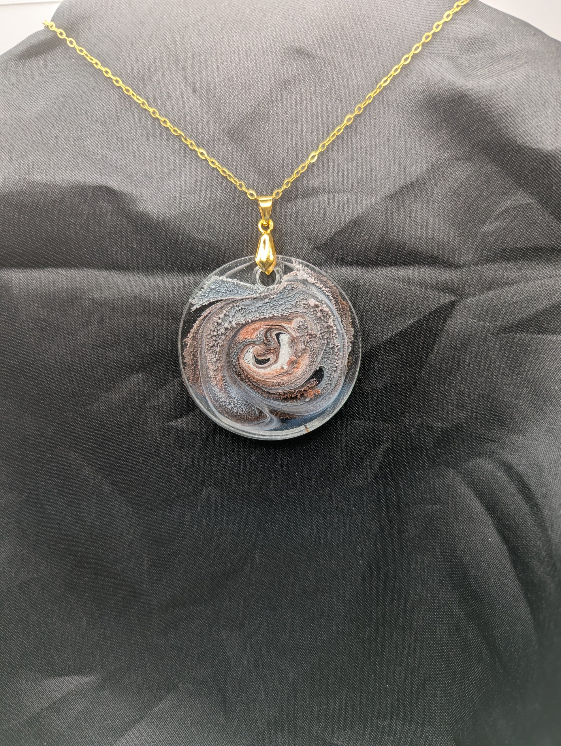 Brown Swirl Circle Pendant with shades of brown, red, & black on a gold pinch bail & golden stainless steel chain. Resin Circle Jewelry Pendant with Petri Effect.