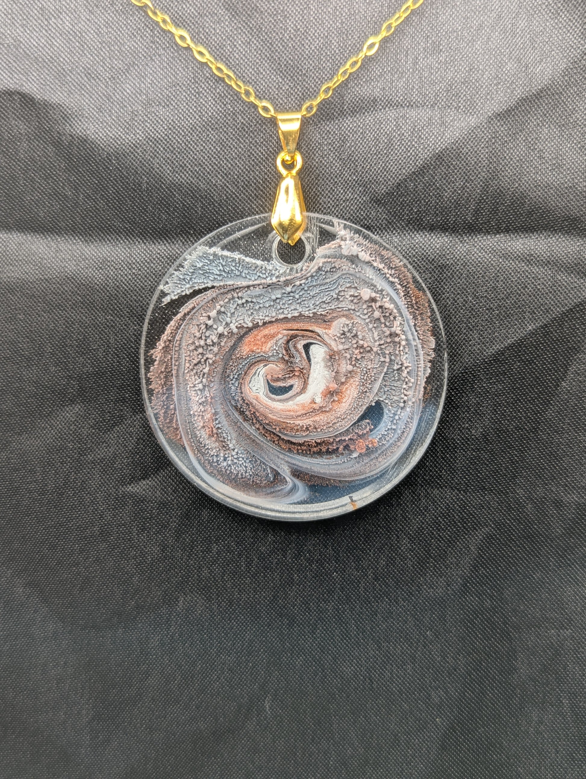 Brown Swirl Circle Pendant with shades of brown, red, & black on a gold pinch bail & golden stainless steel chain. Resin Circle Jewelry Pendant with Petri Effect.
