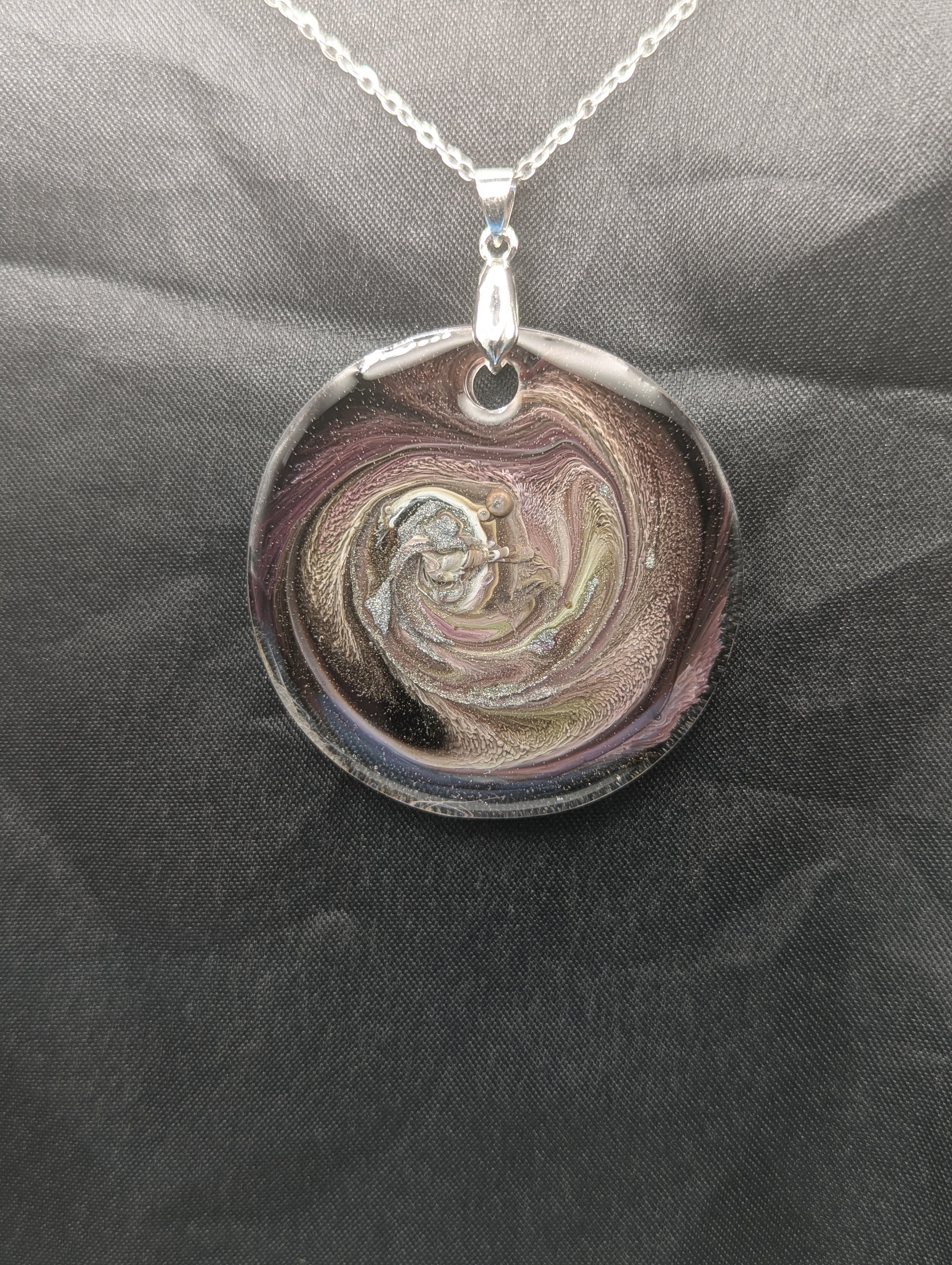 Purple Swirl Circle Pendant with shades of purple, yellow, & black on a silver pinch bail & silver plated stainless steel chain. Resin Circle Jewelry Pendant with Petri Effect.