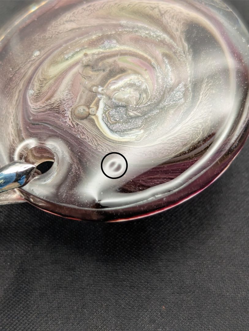 Purple Swirl Circle Pendant with shades of purple, yellow, & black on a silver pinch bail & silver plated stainless steel chain. Resin Circle Jewelry Pendant with Petri Effect.