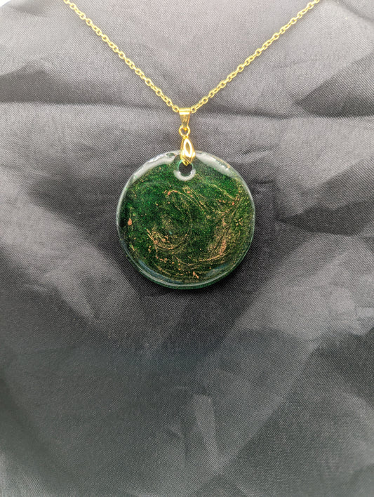 Green Resin Circle Pendant Necklace with swirls of light orange on a gold pinch bail & gold plated metal chain.
