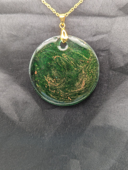 Green Resin Circle Pendant Necklace with swirls of light orange on a gold pinch bail & gold plated metal chain.