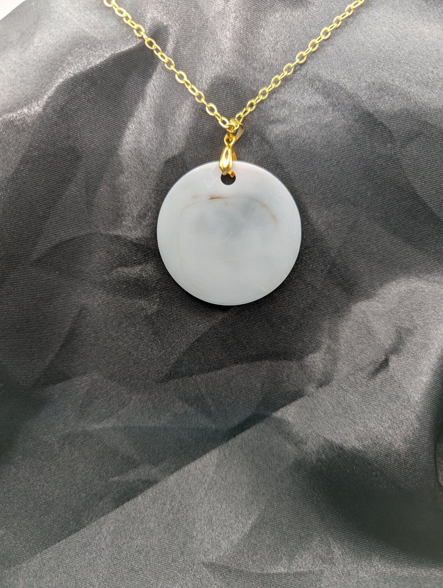 Back view of Brown Swirl Resin Circle necklace pendant on a pinch bail and gold plated metal chain.