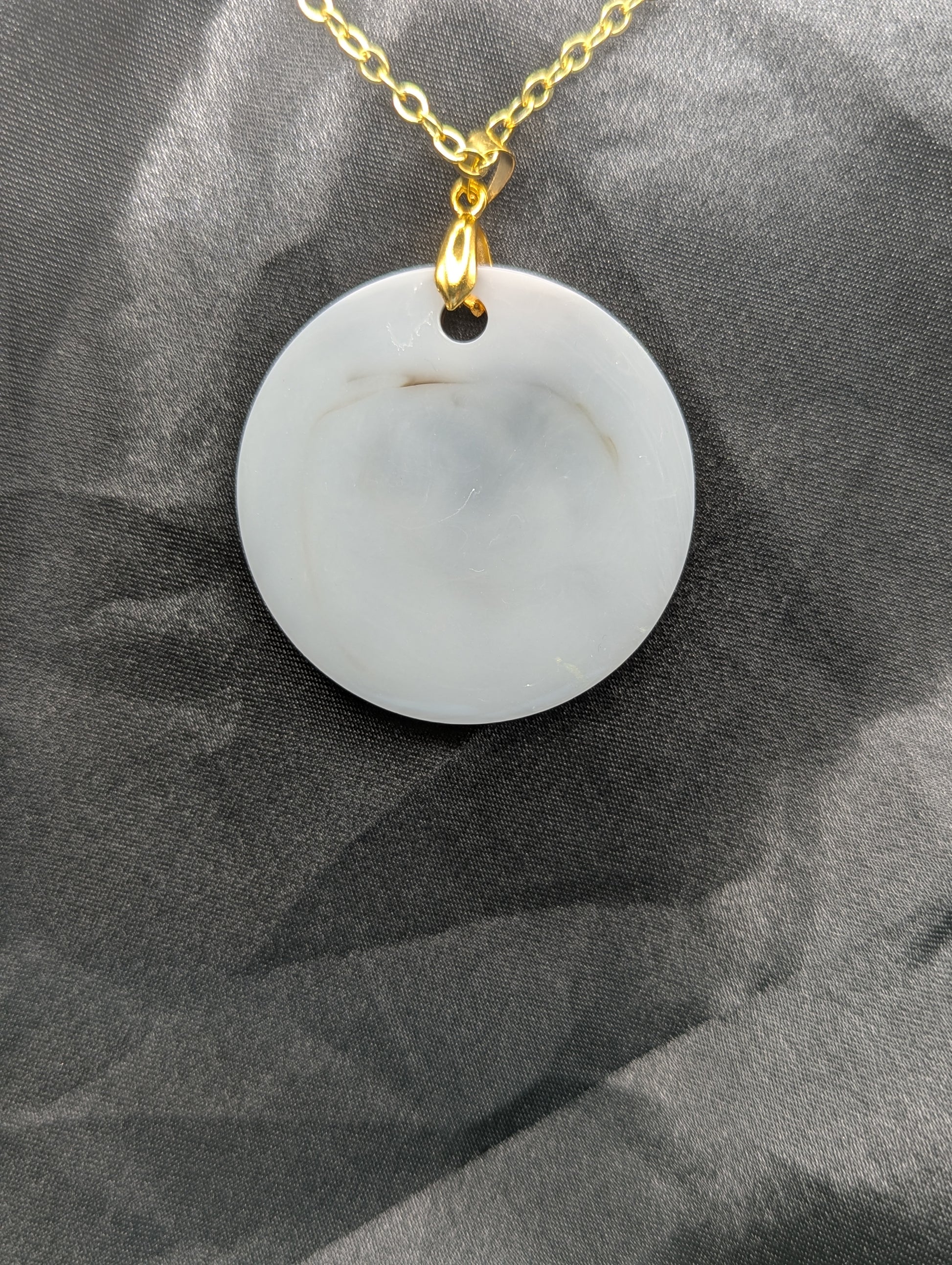 Back view of Brown Swirl Resin Circle necklace pendant on a pinch bail and gold plated metal chain.