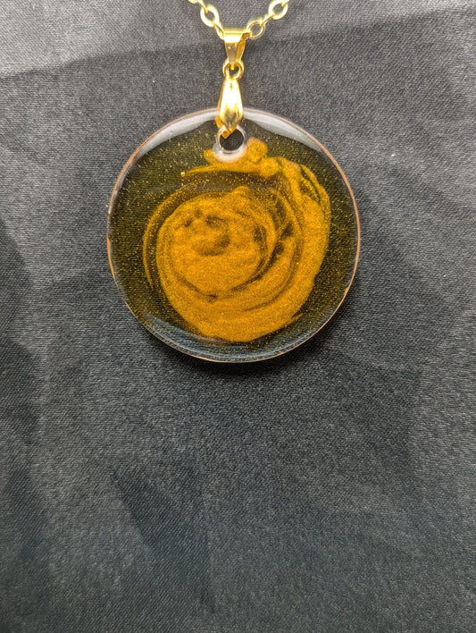 Yellow & orange swirl circle resin pendant on a gold pinch bail & gold plated metal chain.