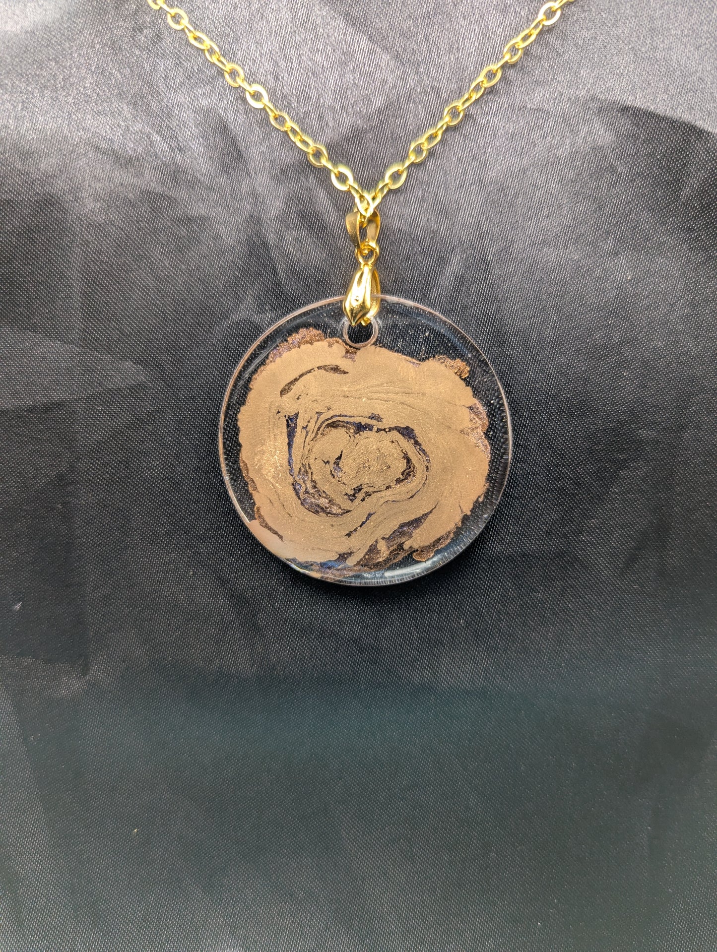 Back view of Gold Swirl Resin Circle pendant on a gold pinch bail & gold plated metal chain.
