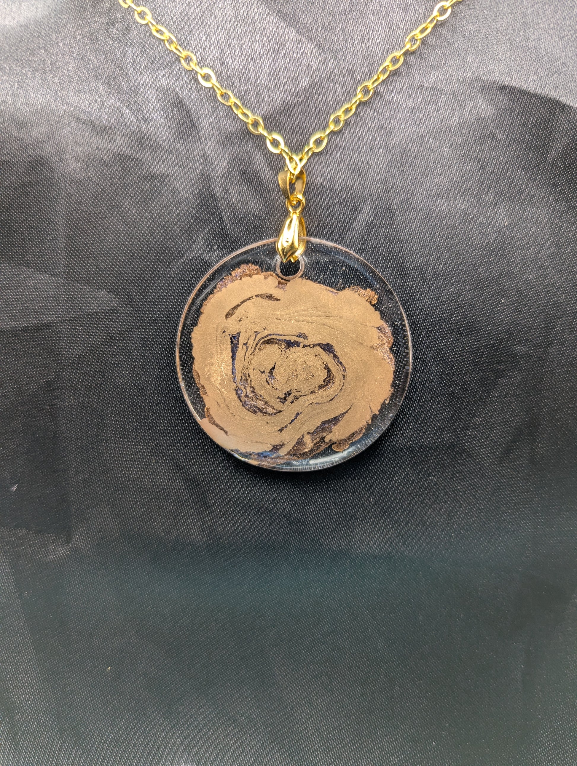 Back view of Gold Swirl Resin Circle pendant on a gold pinch bail & gold plated metal chain.