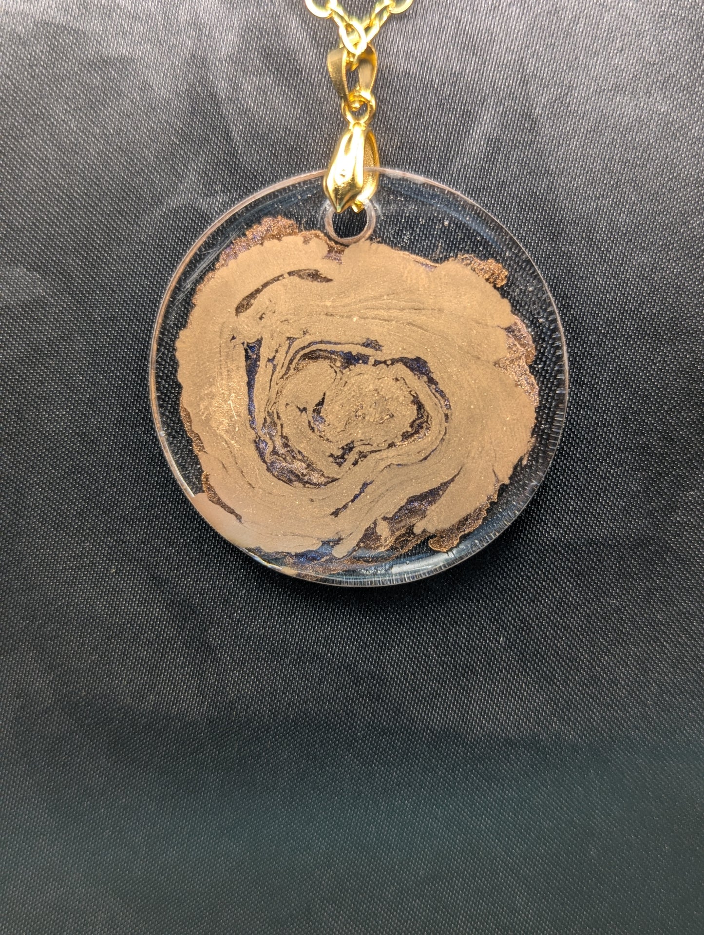 Back view of Gold Swirl Resin Circle pendant on a gold pinch bail & gold plated metal chain.