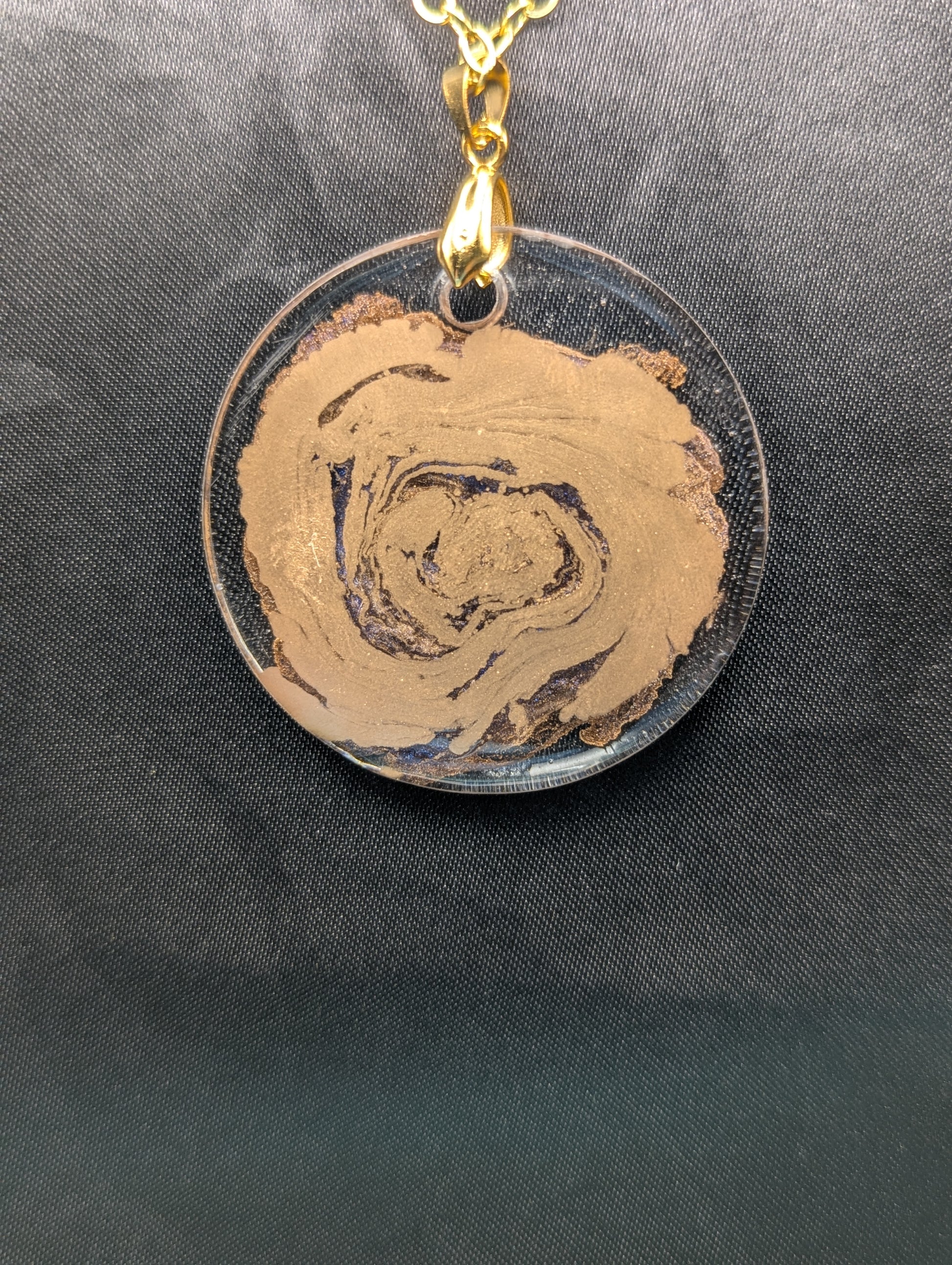 Back view of Gold Swirl Resin Circle pendant on a gold pinch bail & gold plated metal chain.