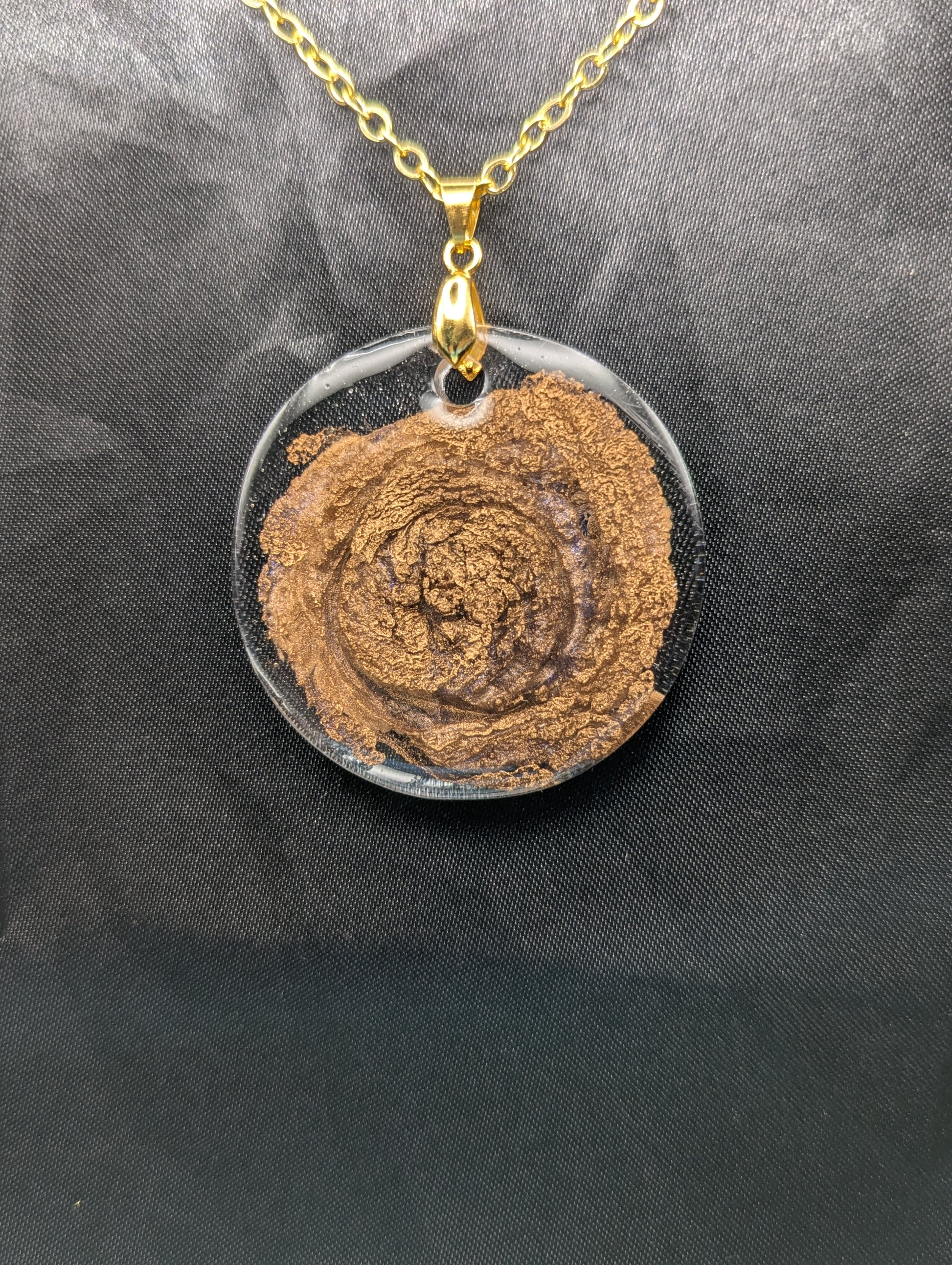Gold Swirl Resin Circle pendant on a gold pinch bail & gold plated metal chain.