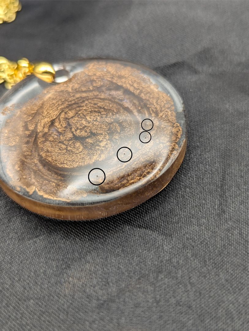 Gold Swirl Resin Circle pendant on a gold pinch bail & gold plated metal chain.