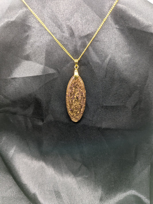 Rich Gold Swirl with dots of purple Ellipse Resin Pendant on a gold pinch bail and a gold plated metal chain.