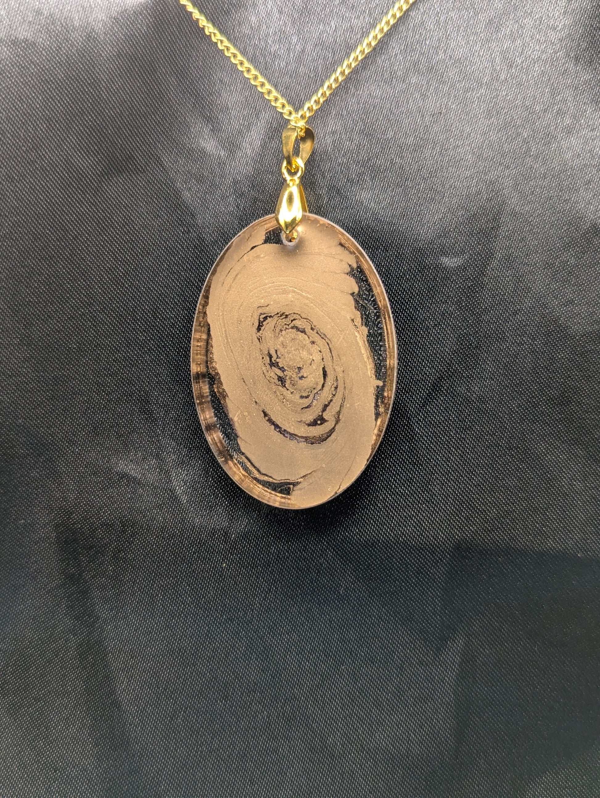 Back view of Rich Gold Swirl Resin Oval Pendant on a gold pinch bail and a gold plated metal chain.
