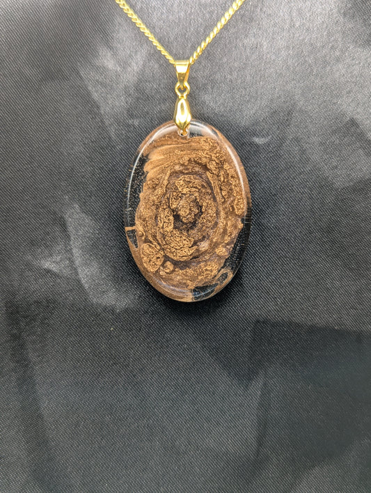 Rich Gold Swirl Resin Oval Pendant on a gold pinch bail and a gold plated metal chain.