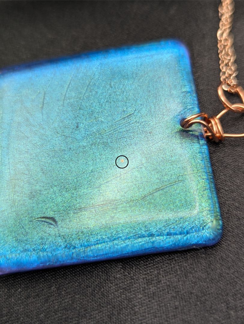 Blue square resin pendant with a color shift background. Resin square necklace on a pure copper wire wrapped bail & rose gold colored stainless steel plated metal chain.