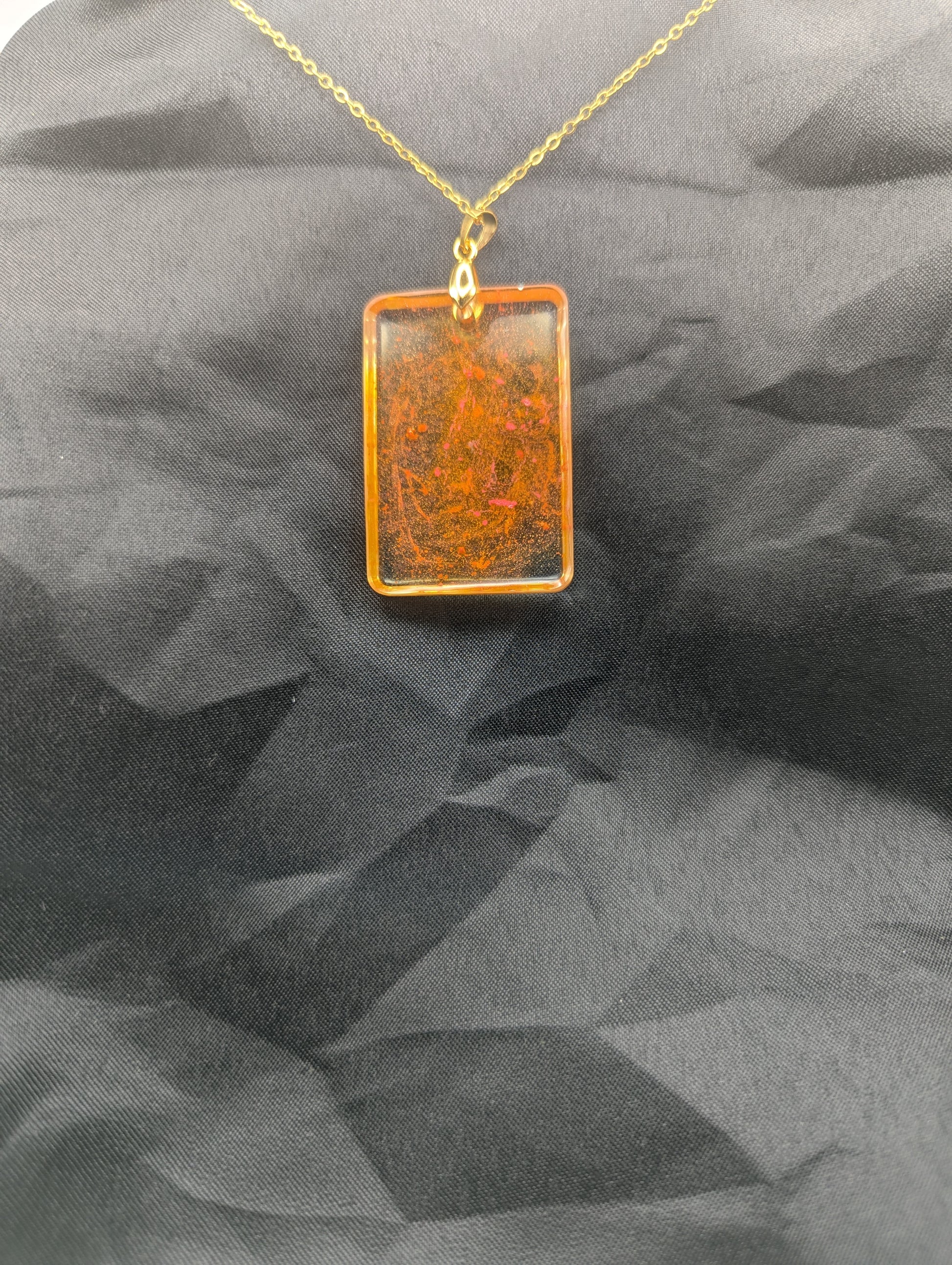 Back view of Yellow & Orange rectangle resin pendant necklace with a gold pinch bail on a gold plated metal chain.