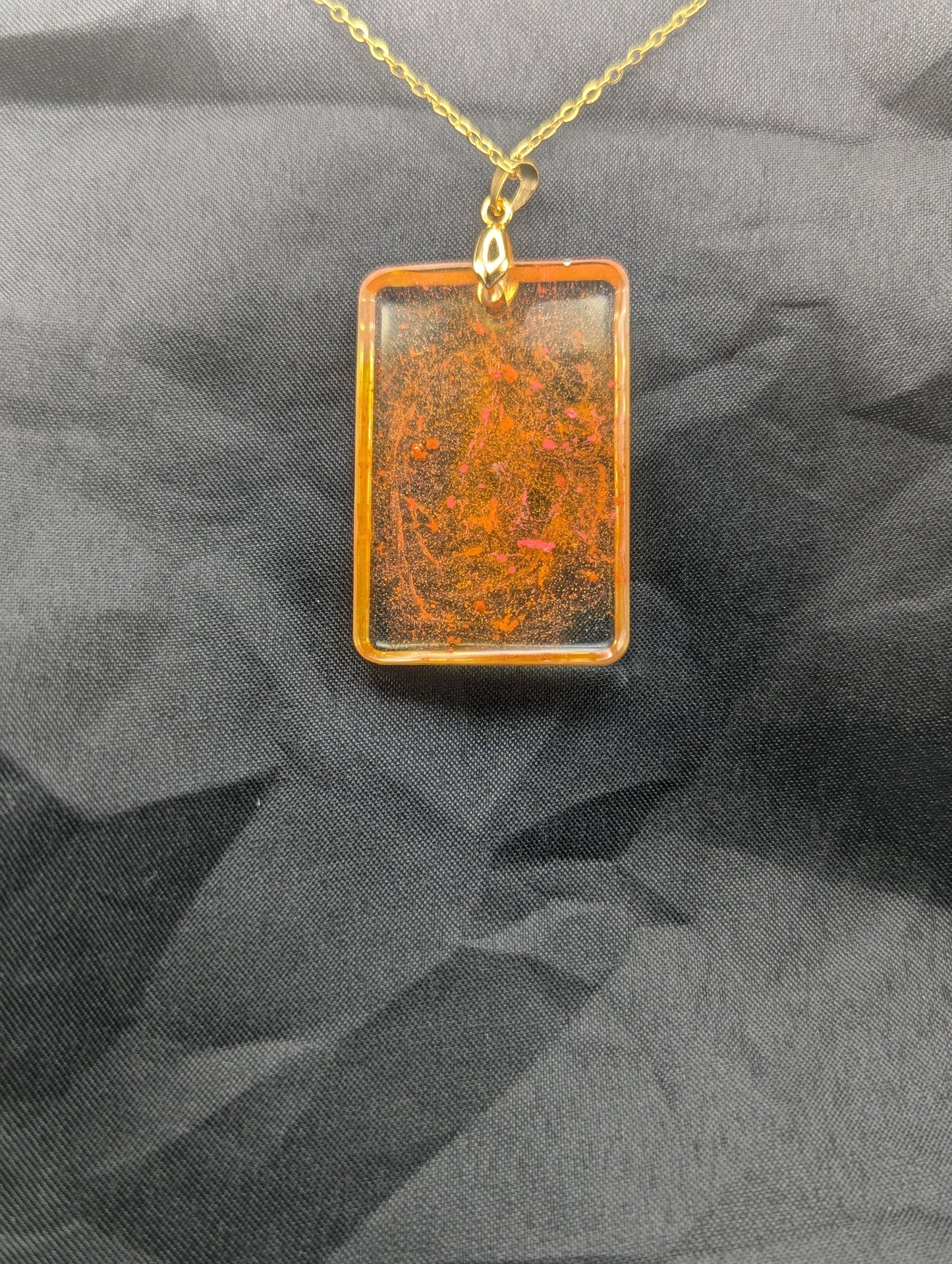 Back view of Yellow & Orange rectangle resin pendant necklace with a gold pinch bail on a gold plated metal chain.