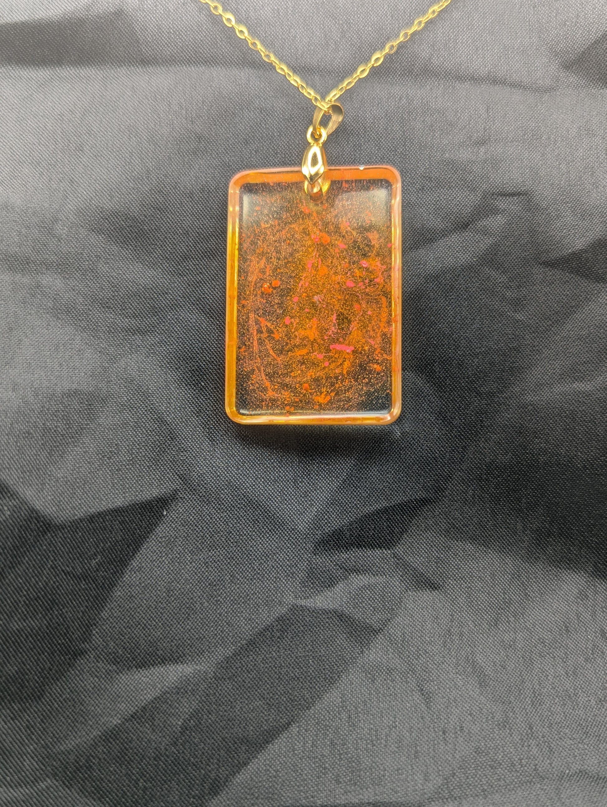 Back view of Yellow & Orange rectangle resin pendant necklace with a gold pinch bail on a gold plated metal chain.