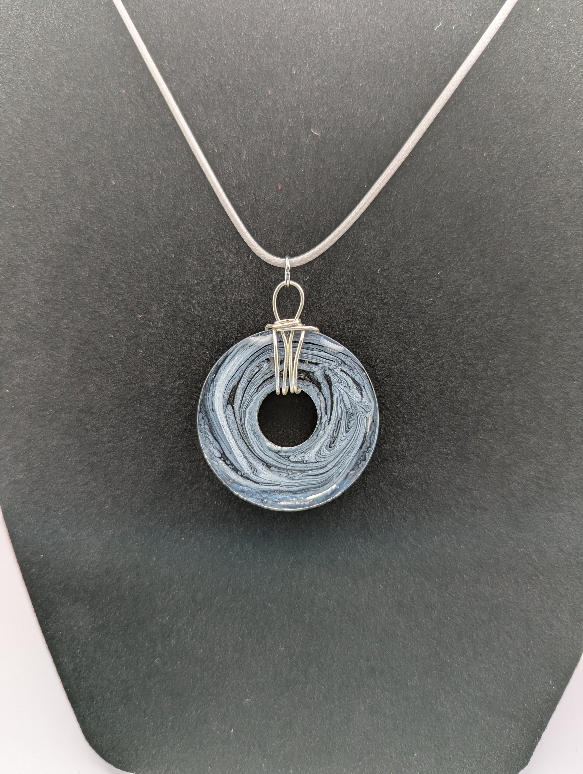 Back View of Wire Wrapped Donut Resin Pendant Necklace - Petri Effect with shades of black, white, & dark smokey bluish gray swirls. Resin Necklace on a waxed cotton cord. 