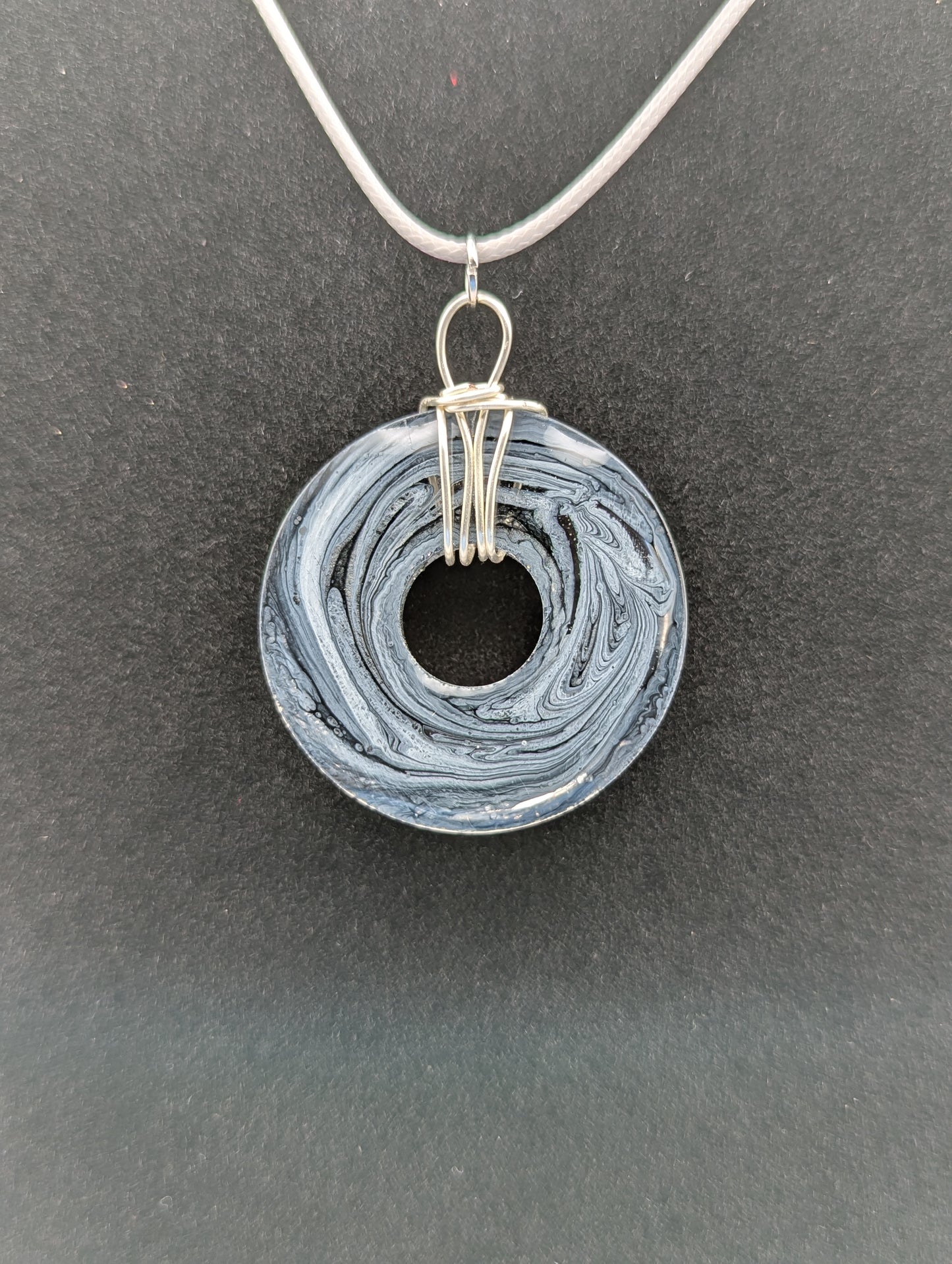 Back View of Wire Wrapped Donut Resin Pendant Necklace - Petri Effect with shades of black, white, & dark smokey bluish gray swirls. Resin Necklace on a waxed cotton cord.