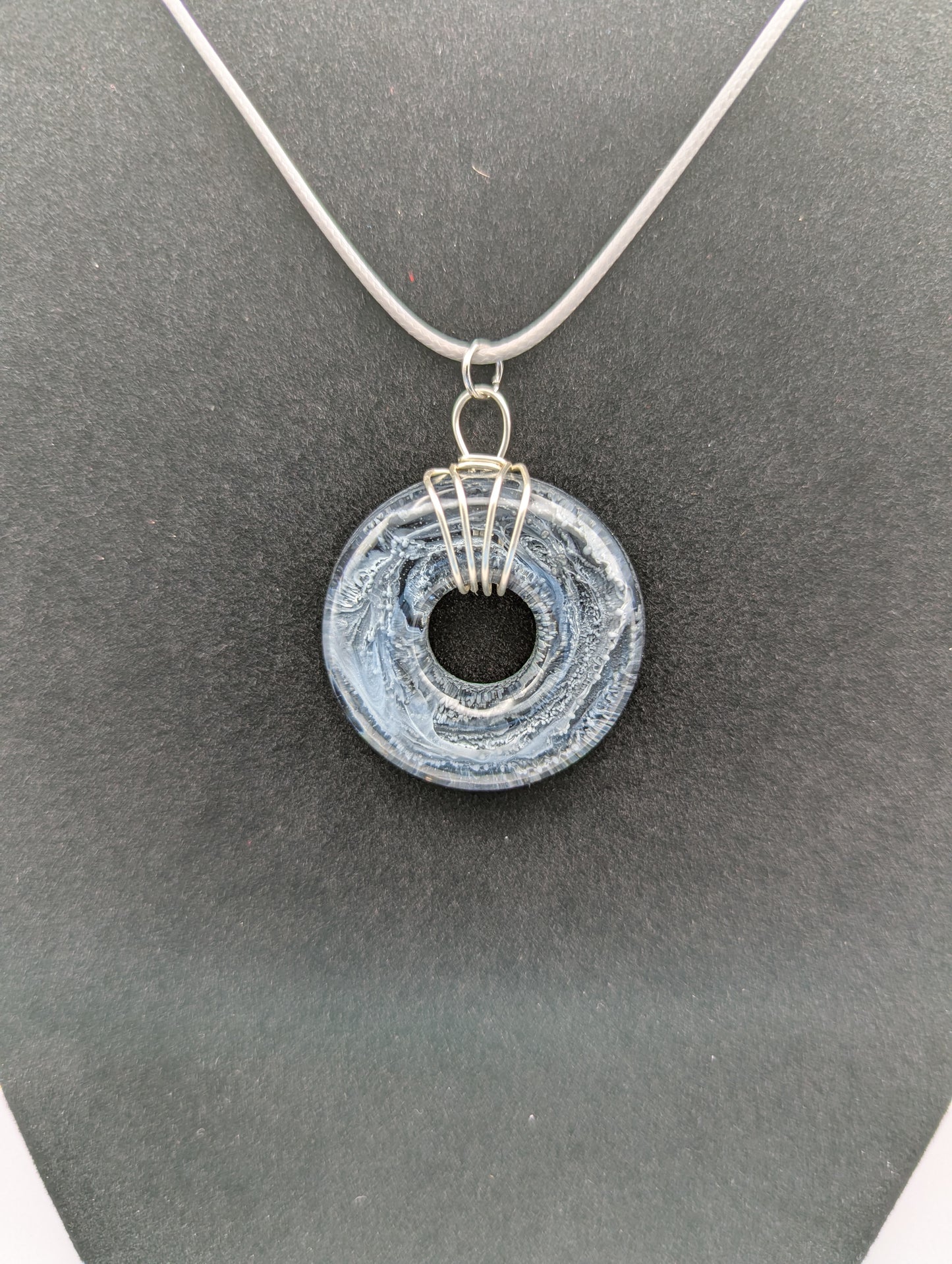 Wire Wrapped Donut Resin Pendant Necklace - Petri Effect with shades of black, white, & dark smokey bluish gray swirls. Resin Necklace on a waxed cotton cord.