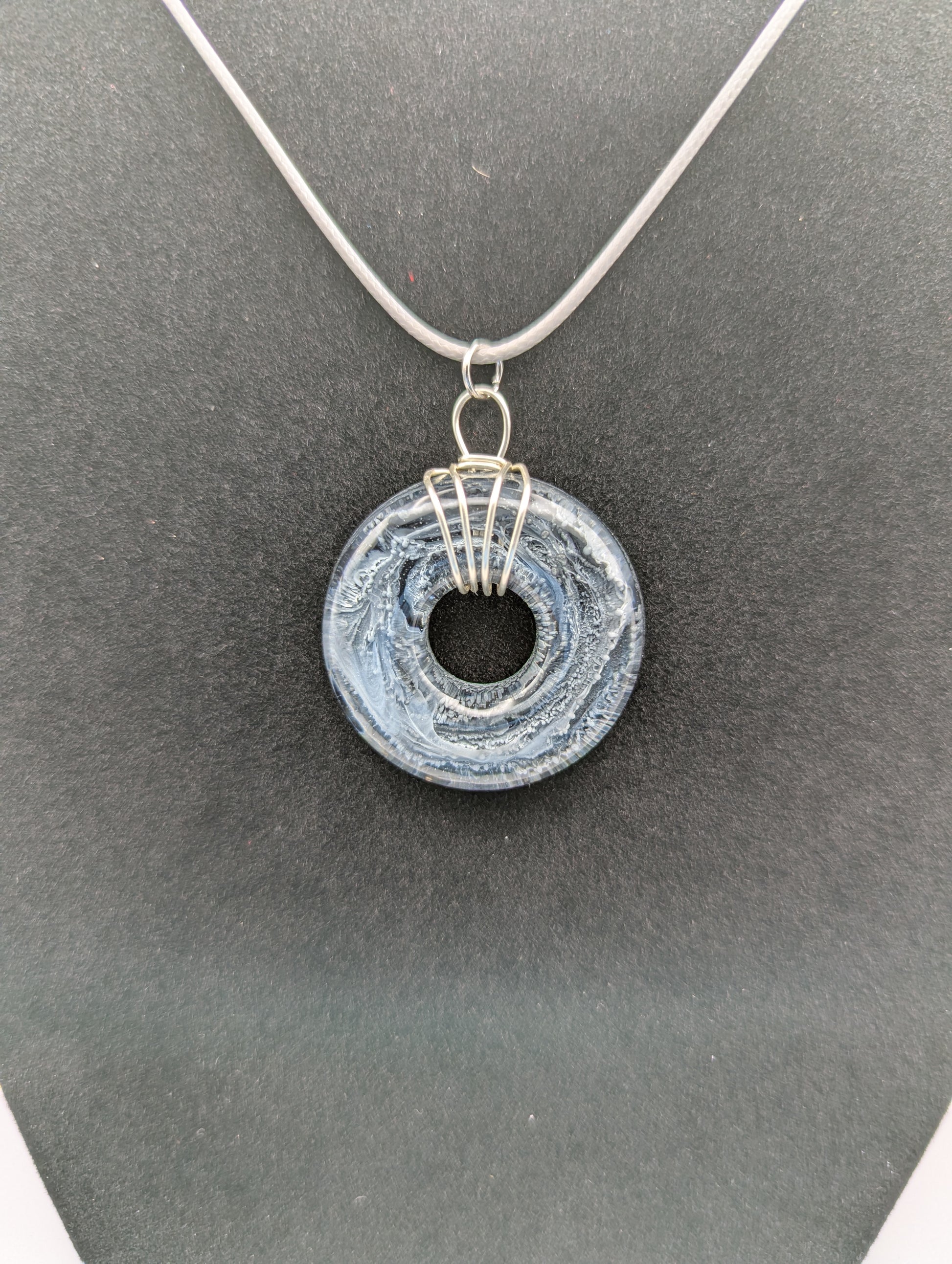 Wire Wrapped Donut Resin Pendant Necklace - Petri Effect with shades of black, white, & dark smokey bluish gray swirls. Resin Necklace on a waxed cotton cord.