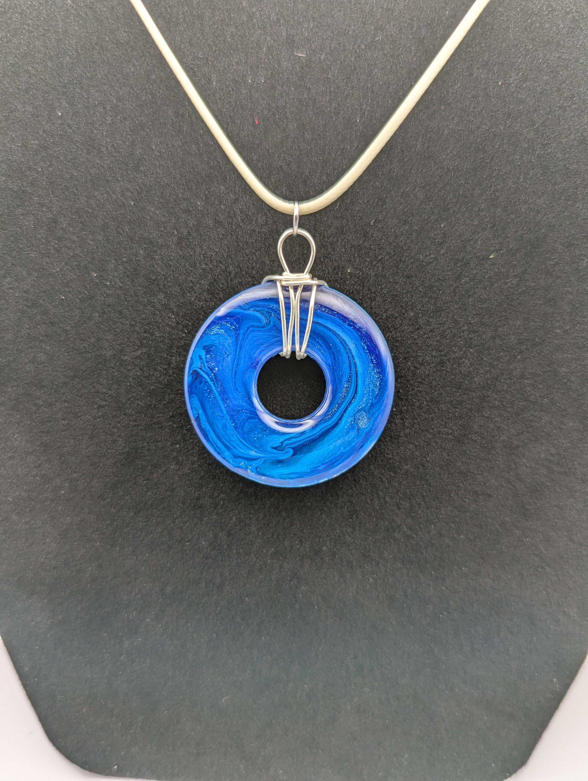 Back view of Wire Wrapped Donut Resin Pendant Necklace - Petri Effect with shades of blue. Resin Necklace on a waxed cotton cord.