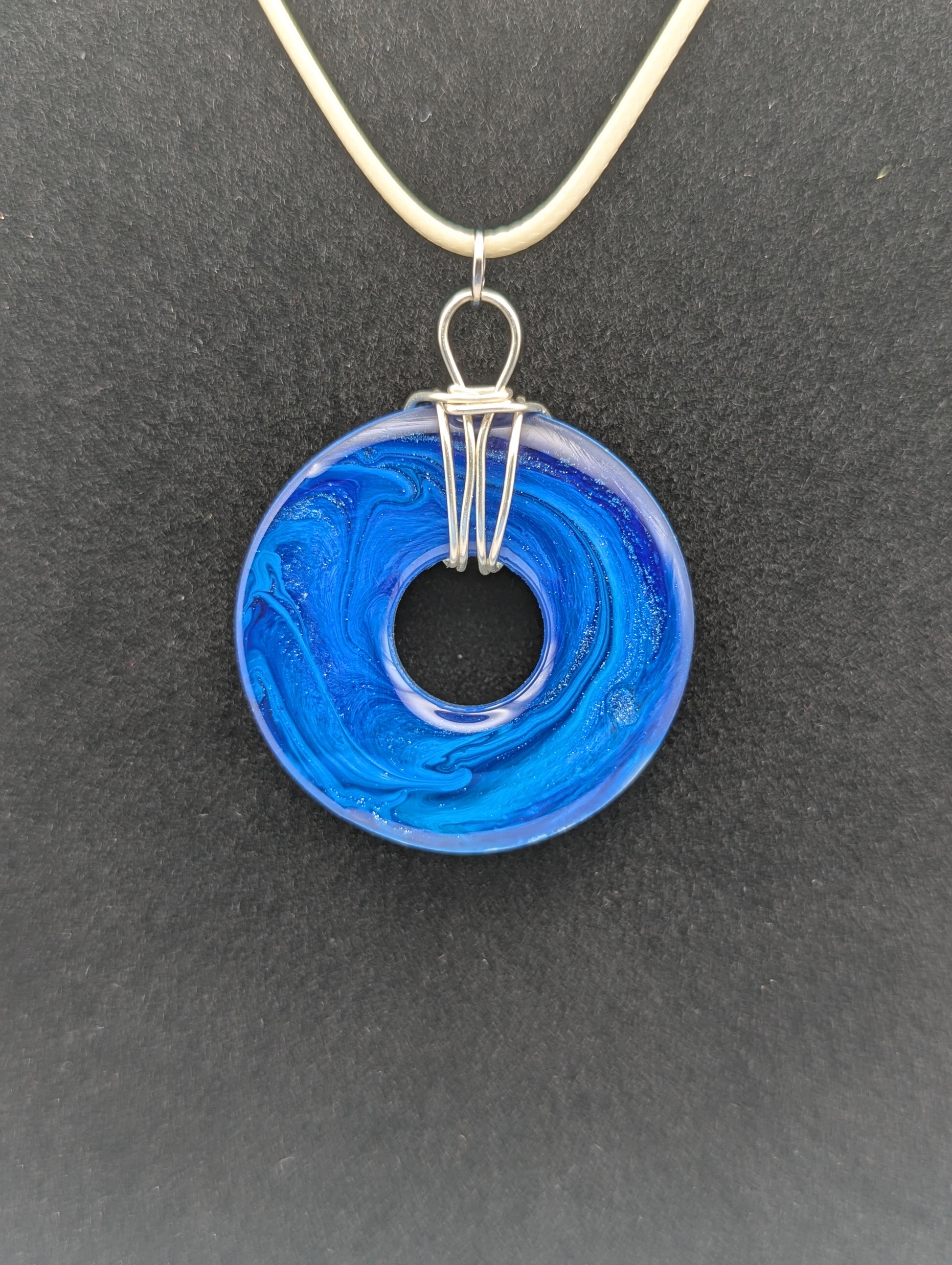 Back view of Wire Wrapped Donut Resin Pendant Necklace - Petri Effect with shades of blue. Resin Necklace on a waxed cotton cord.