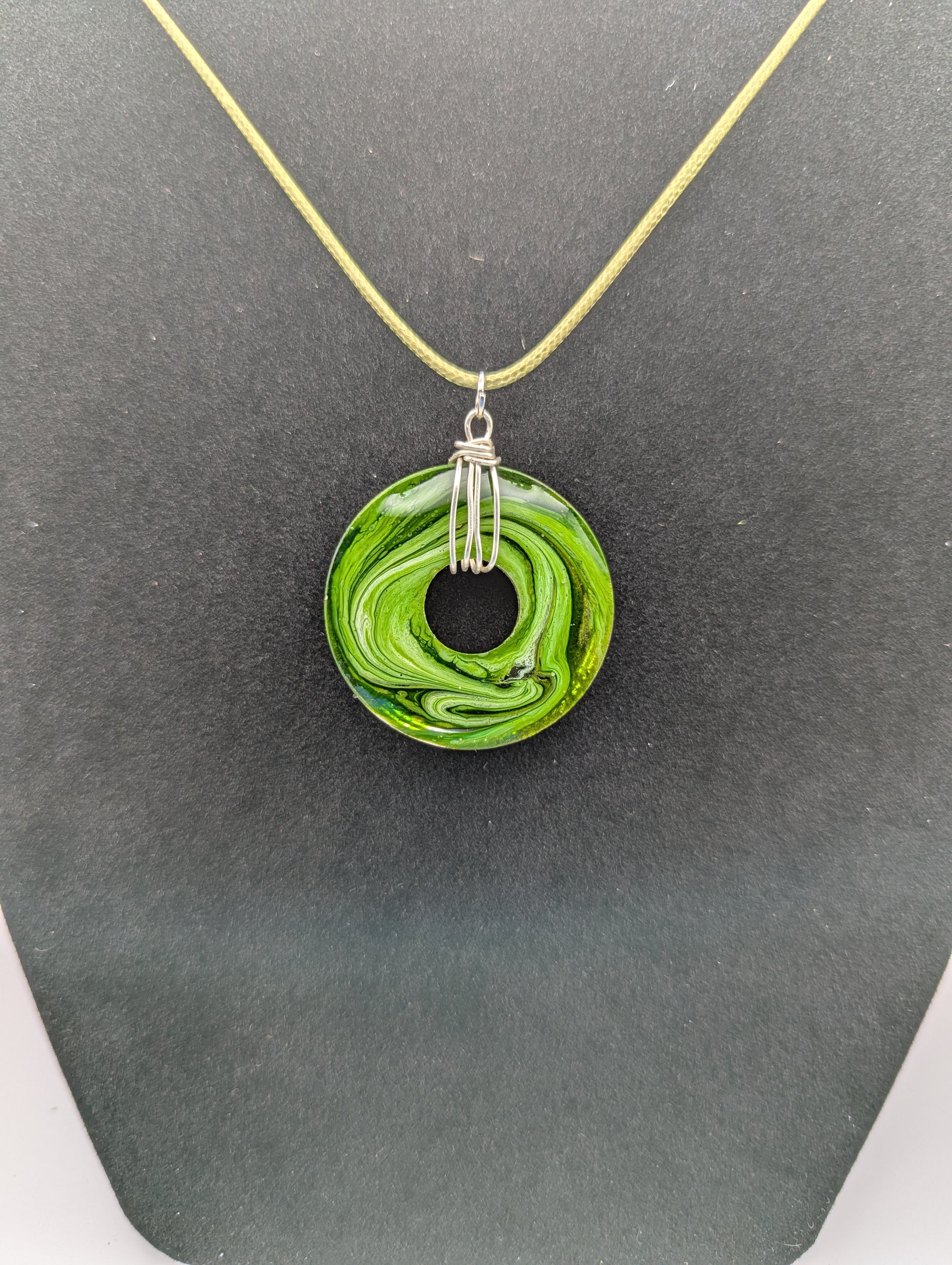 Back view of Wire Wrapped Donut Resin Pendant Necklace - Petri Effect with shades of green. Resin Necklace on a waxed cotton cord.