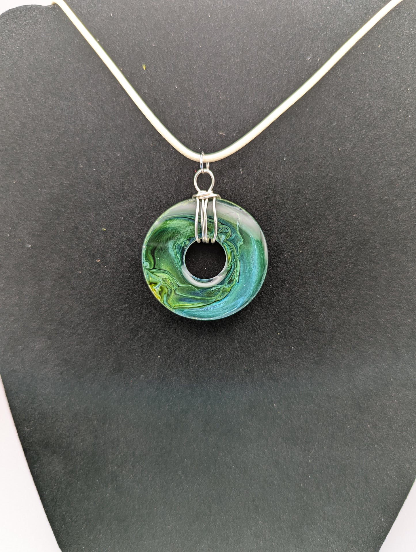 Back view of Wire Wrapped Donut Resin Pendant Necklace - Petri Effect with shades of blue, green, & yellow swirls. Resin Necklace on a waxed cotton cord.