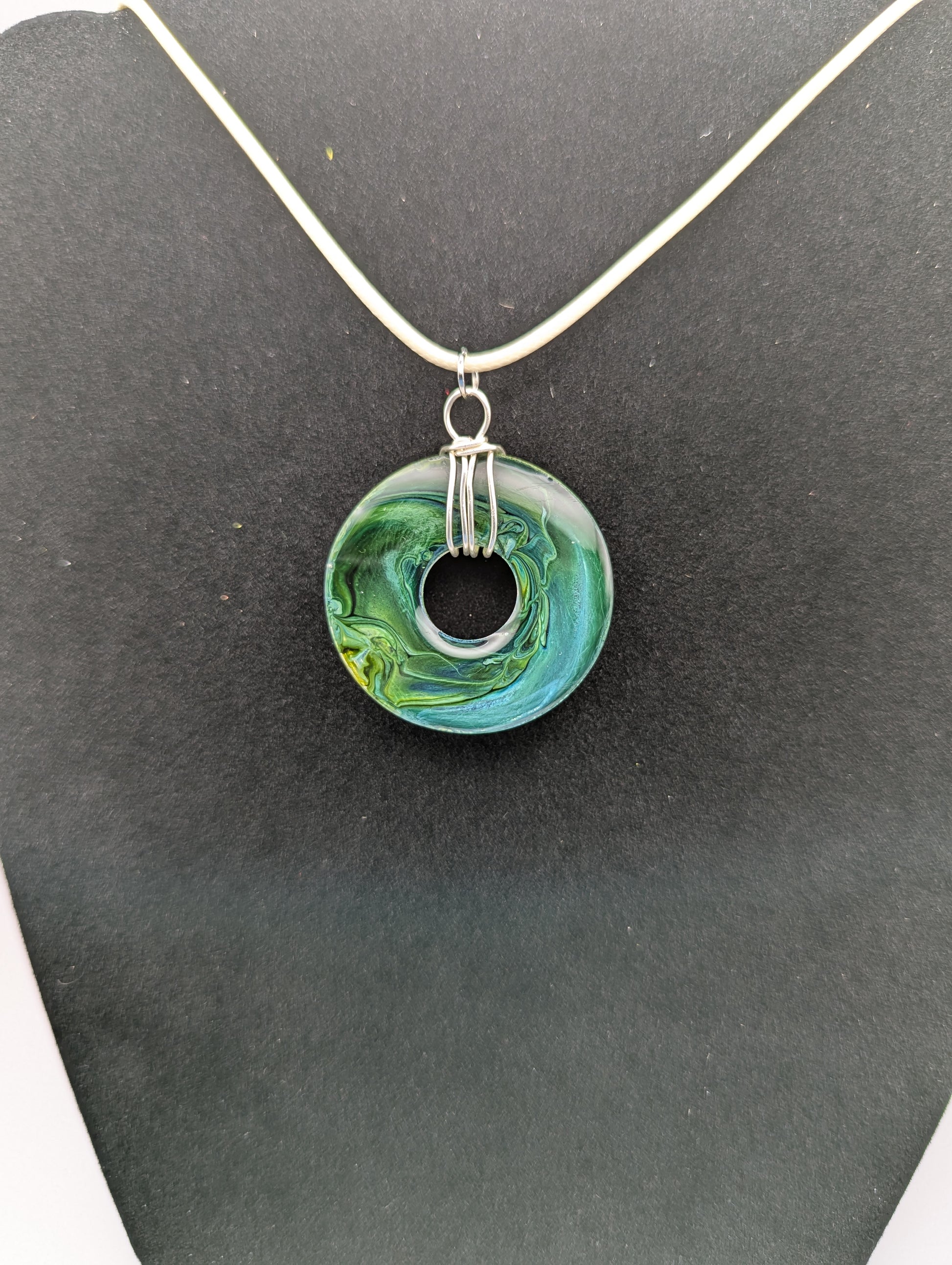 Back view of Wire Wrapped Donut Resin Pendant Necklace - Petri Effect with shades of blue, green, & yellow swirls. Resin Necklace on a waxed cotton cord.