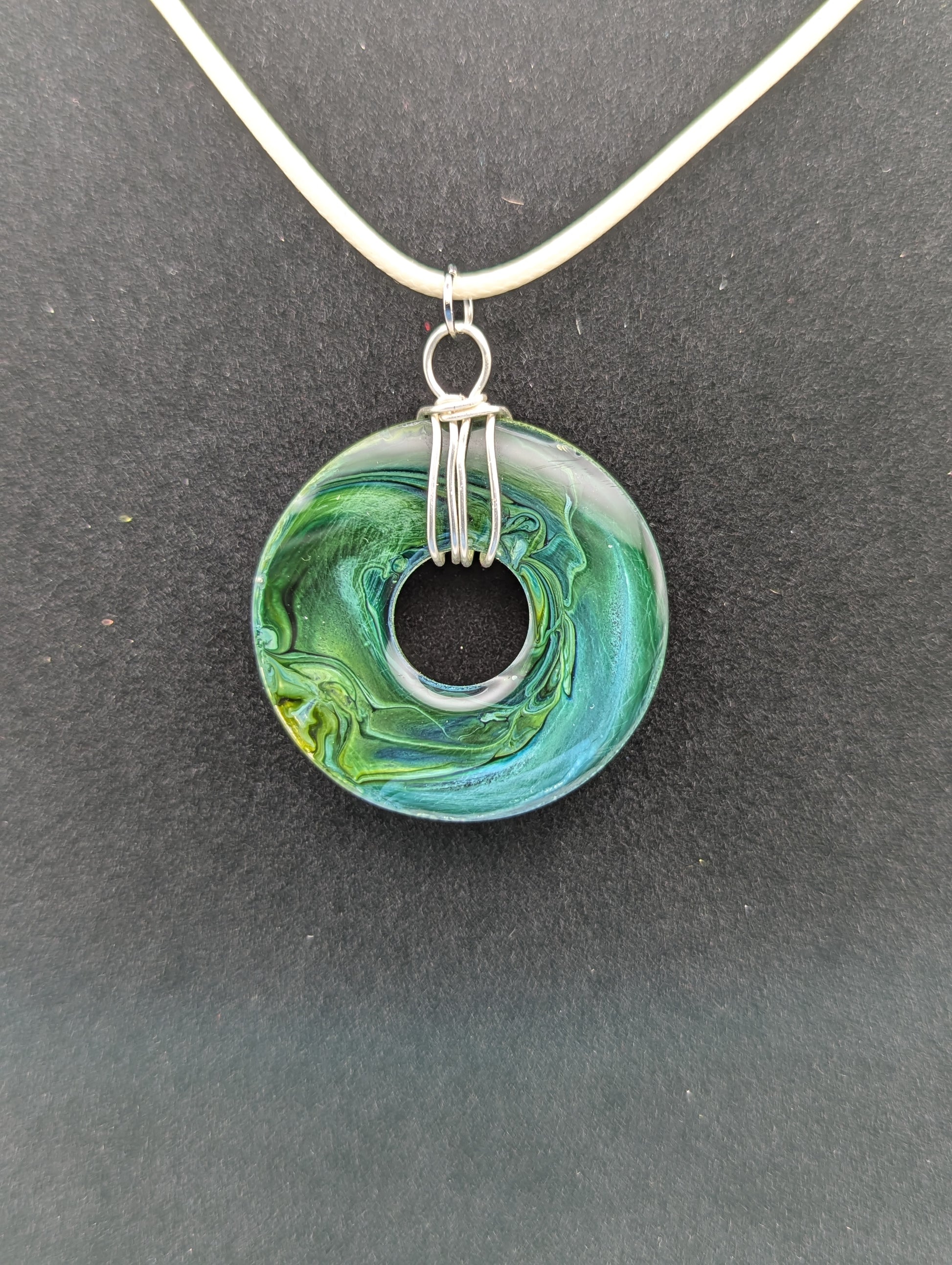 Back view of Wire Wrapped Donut Resin Pendant Necklace - Petri Effect with shades of blue, green, & yellow swirls. Resin Necklace on a waxed cotton cord.