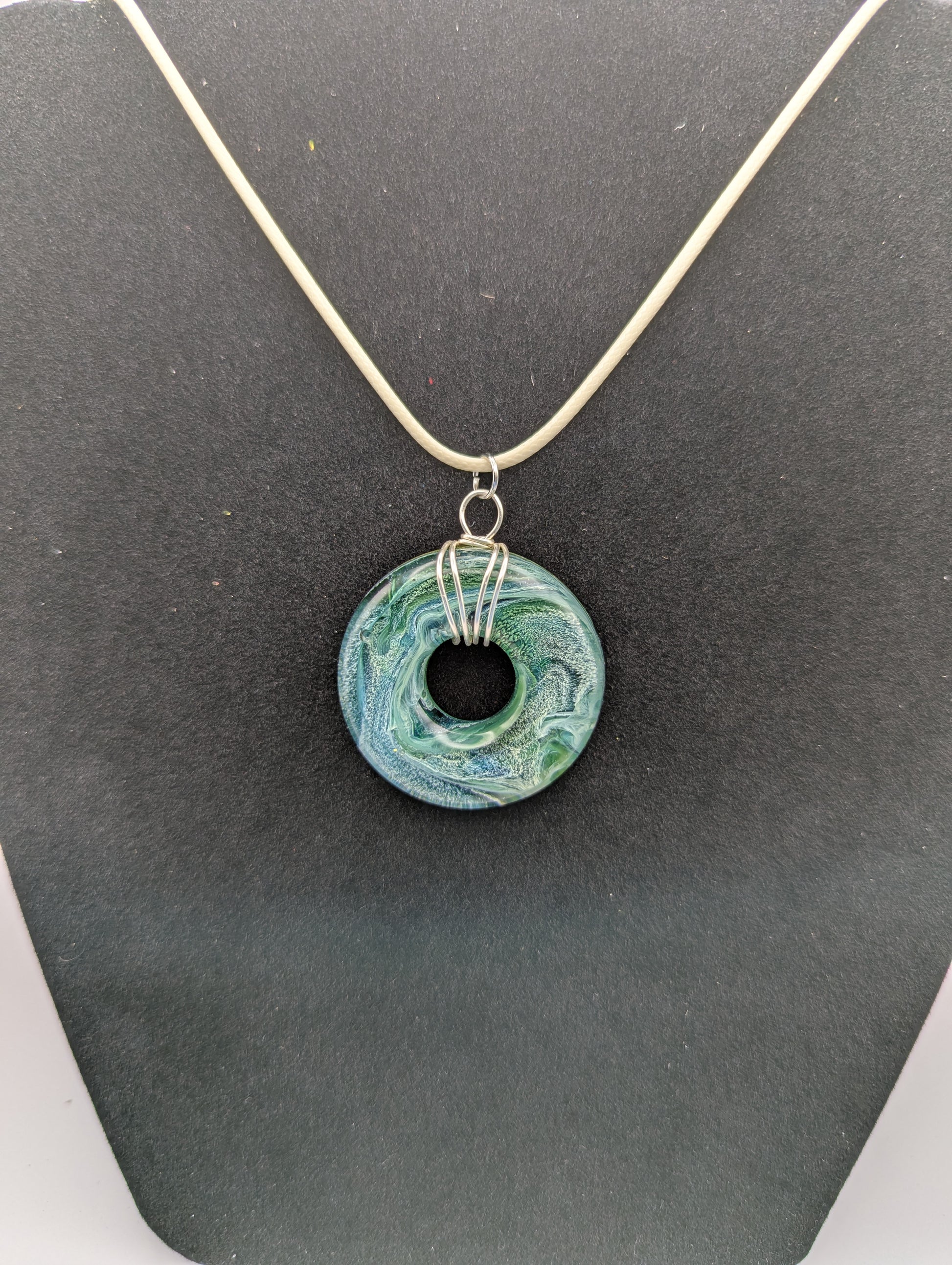 Wire Wrapped Donut Resin Pendant Necklace - Petri Effect with shades of blue, green, & yellow swirls. Resin Necklace on a waxed cotton cord.