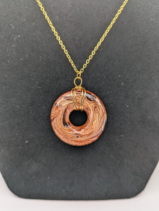Wire Wrapped Donut Resin Pendant Necklace - Petri Effect with shades of orange & red swirls. Resin Necklace on a gold plated chain.