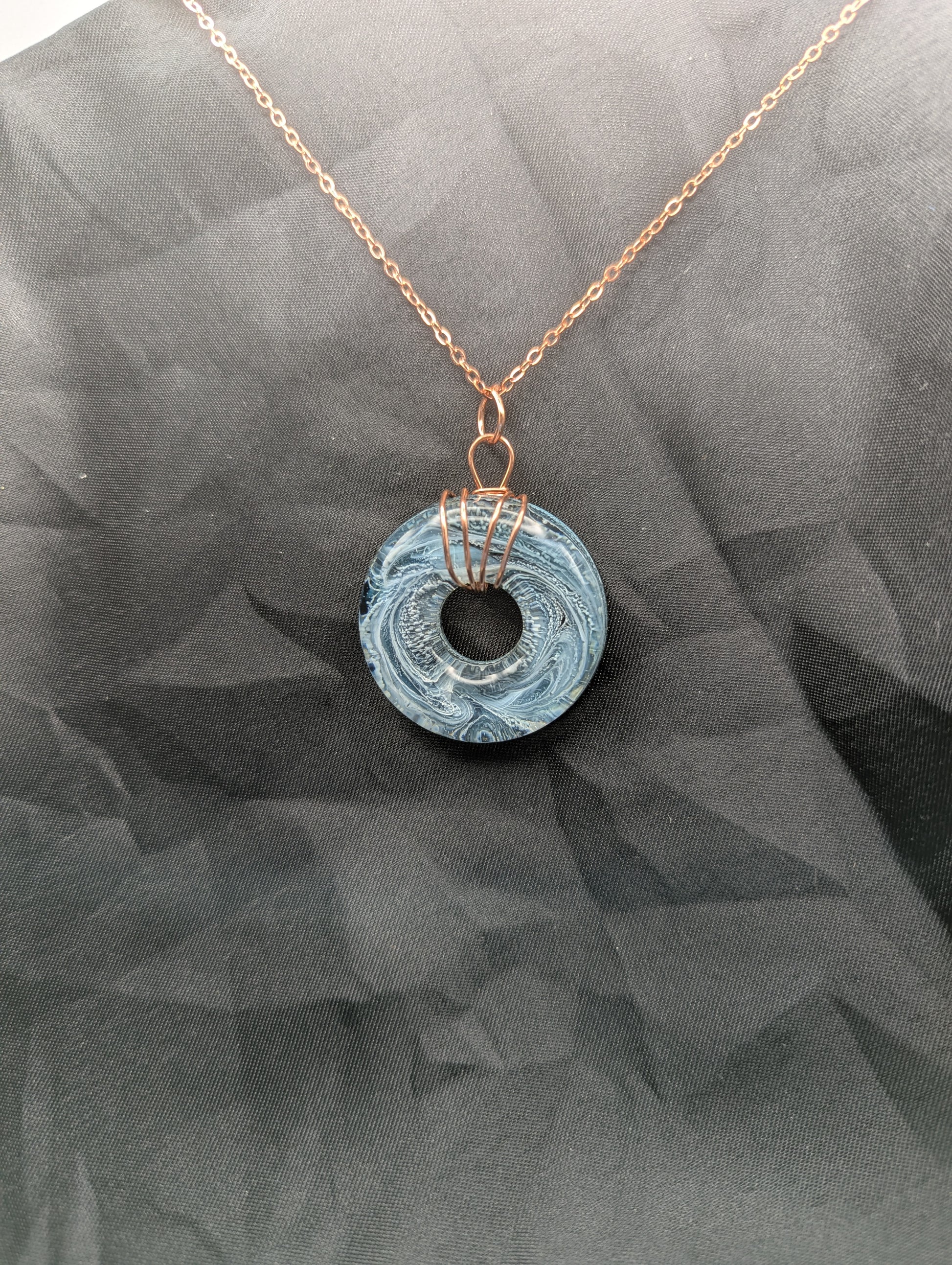 Wire Wrapped Donut Resin Pendant Necklace - Petri Effect with shades of blue & black swirls. Resin Necklace on copper plated stainless steel chain.