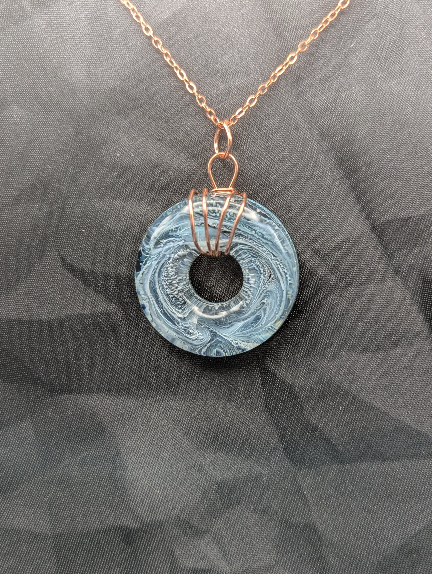Wire Wrapped Donut Resin Pendant Necklace - Petri Effect with shades of blue & black swirls. Resin Necklace on copper plated stainless steel chain.