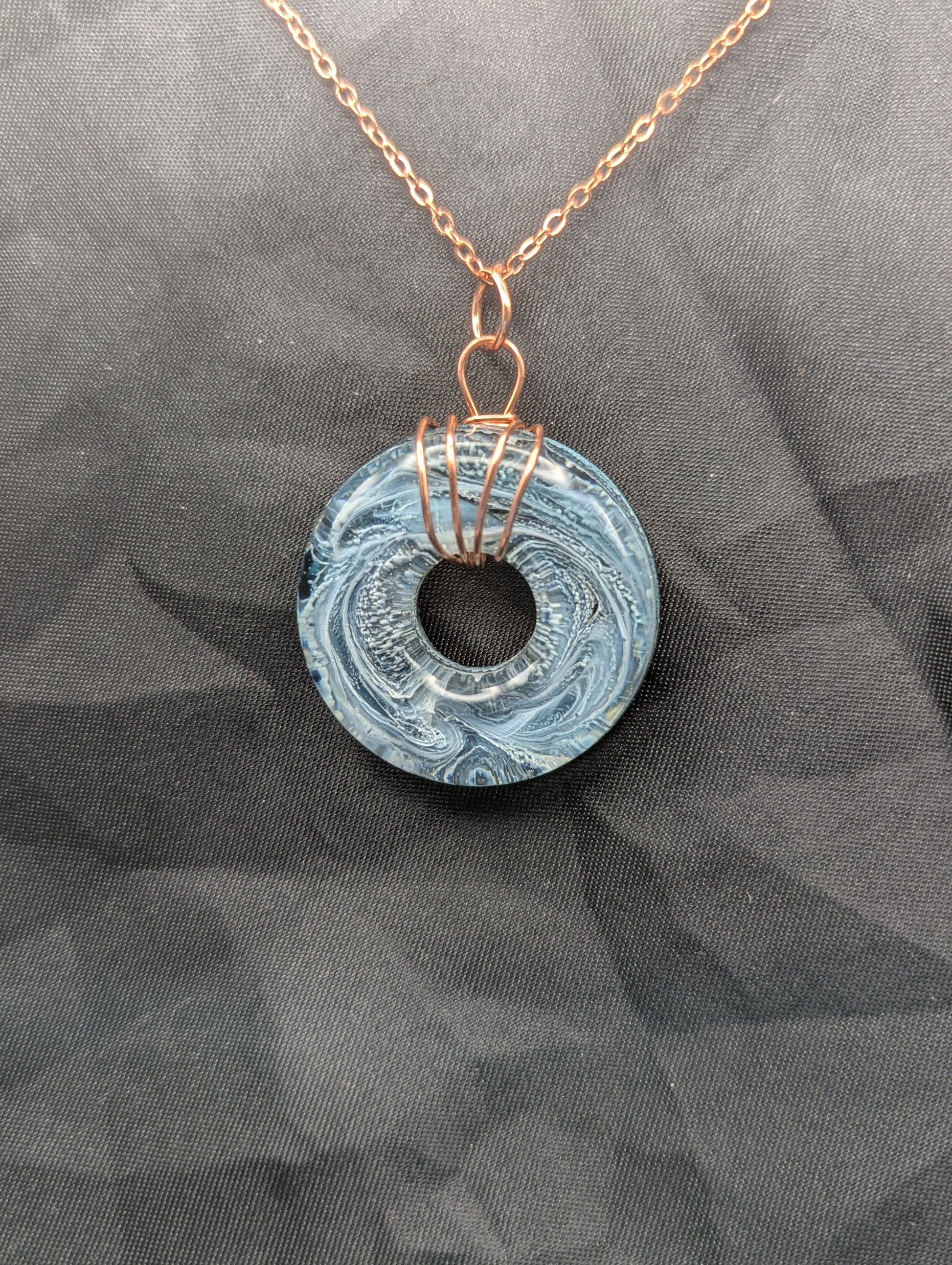 Wire Wrapped Donut Resin Pendant Necklace - Petri Effect with shades of blue & black swirls. Resin Necklace on copper plated stainless steel chain.