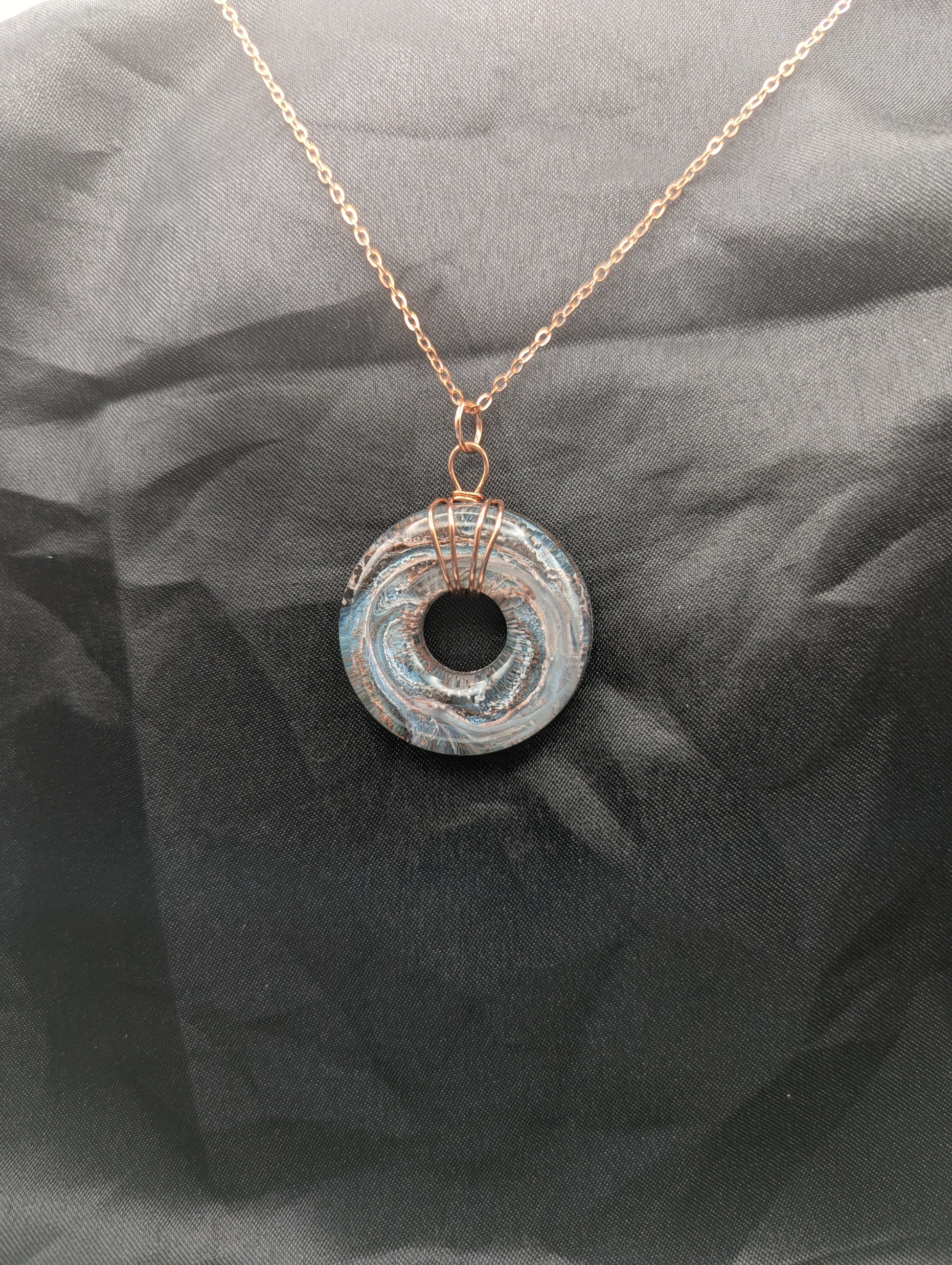 Wire Wrapped Donut Resin Pendant Necklace - Petri Effect with shades of blue & metallic bronze swirls. Resin Necklace on a rose gold colored stainless steel metal chain