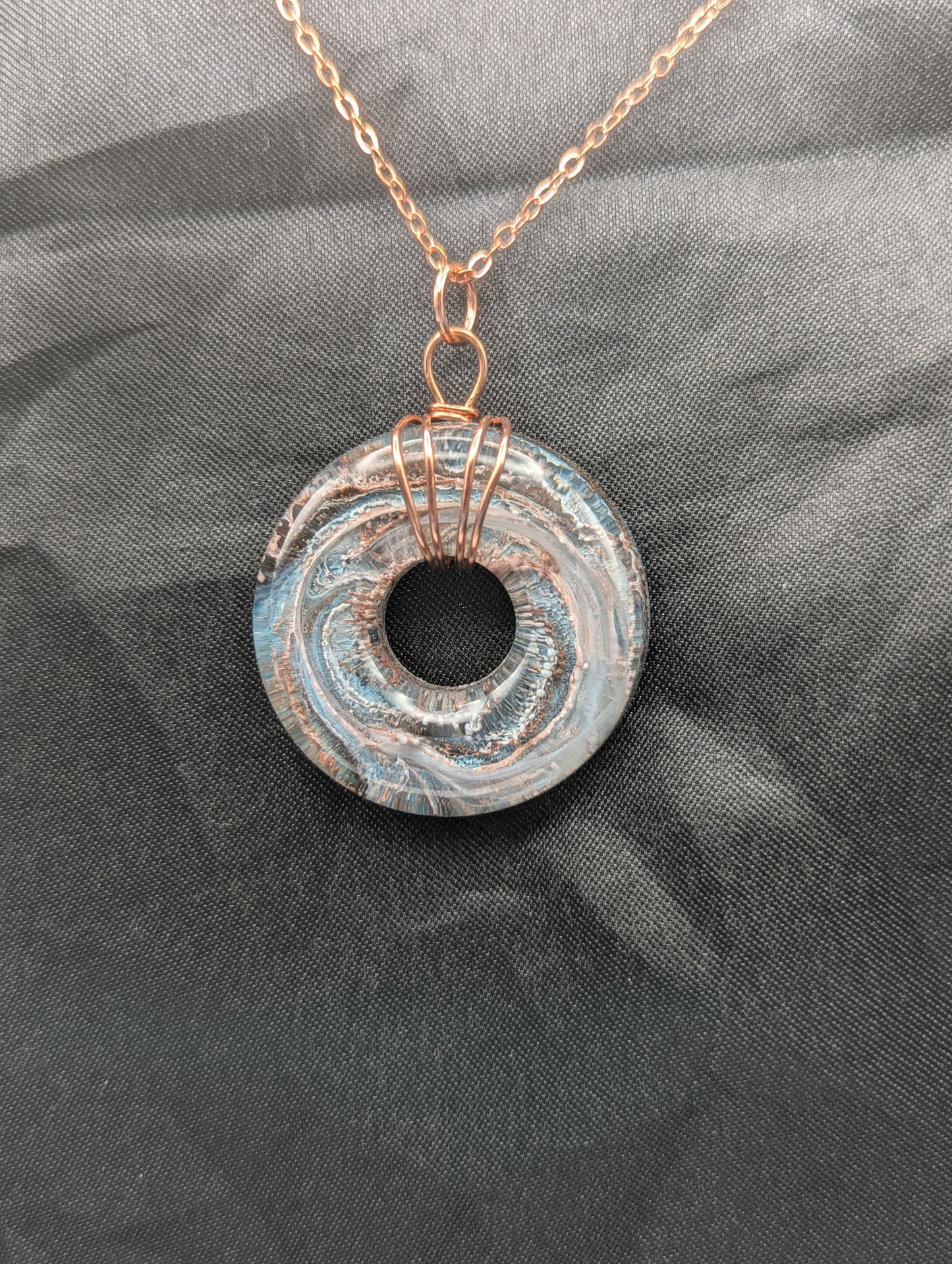 Wire Wrapped Donut Resin Pendant Necklace - Petri Effect with shades of blue & metallic bronze swirls. Resin Necklace on a rose gold colored stainless steel metal chain