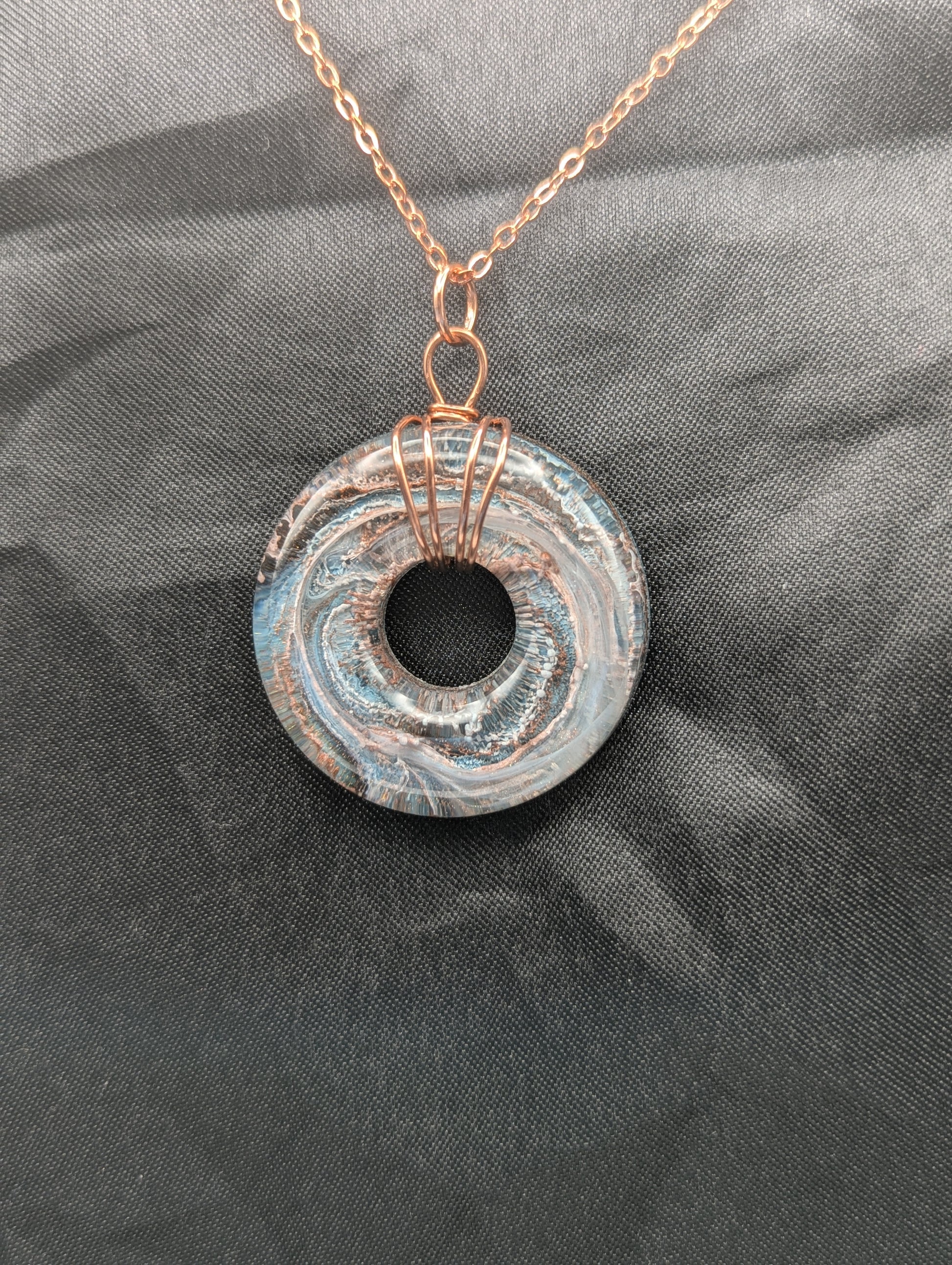 Wire Wrapped Donut Resin Pendant Necklace - Petri Effect with shades of blue & metallic bronze swirls. Resin Necklace on a rose gold colored stainless steel metal chain