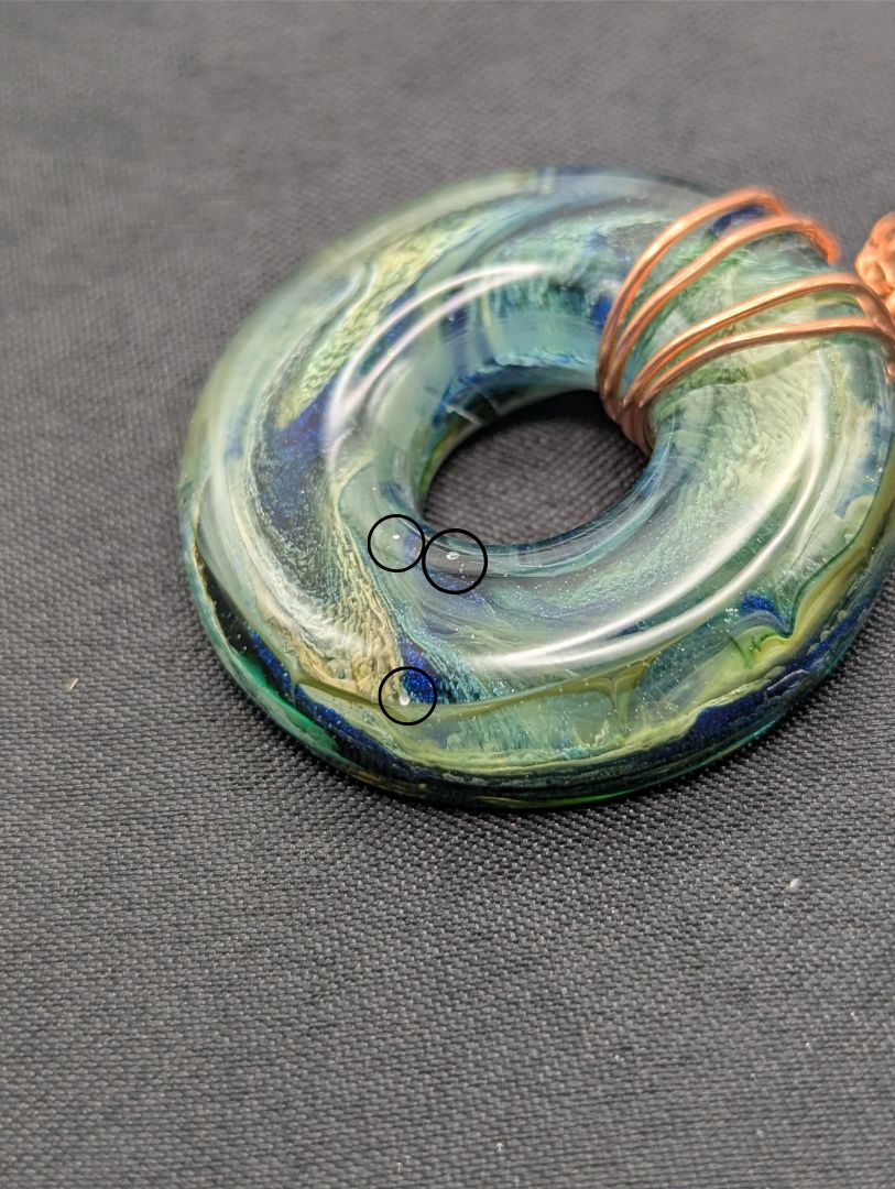 Wire Wrapped Donut Resin Pendant Necklace - Petri Effect with shades of blue, green, & yellow swirls. Resin Necklace on a rose gold colored stainless steel metal chain.